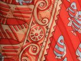 a close up of a red tie with fish on it