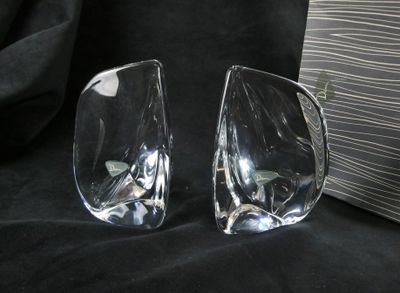 two clear glass vases sitting on a black cloth