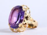 une image d'une bague sertie d'une grosse pierre violette