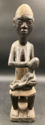 an image of a statue of a man sitting on a stool