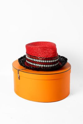 un chapeau rouge posé sur une boîte orange