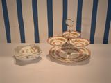 a table with plates and bowls on it with a blue and white striped wall in the background