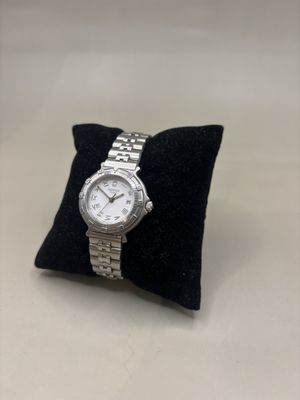 une photo d'une montre posée sur un oreiller, sur une table