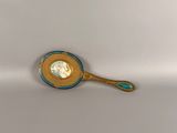 a gold spoon with a blue handle sitting on top of a white surface