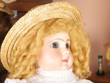 a doll that is sitting on a chair with a hat on