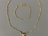 a gold necklace and bracelet set with a cross on it