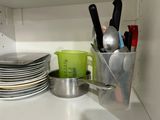 a lot of dishes and utensils on the shelf