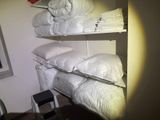 quelques coussins blancs sont empilés sur une étagère dans une pièce
