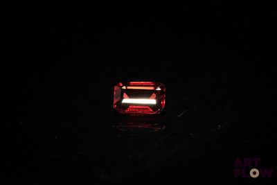 a close up of a red light shining on a black surface