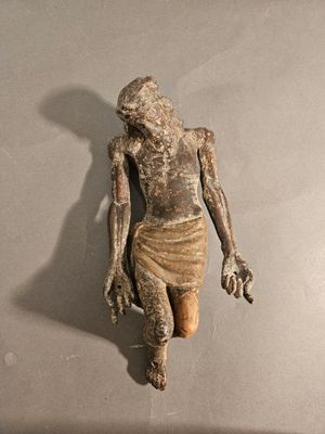 statue d'un homme tenant un couteau à la main, posée sur une surface grise