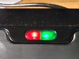 a close up of a red and green light on a black device