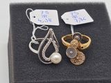 deux bagues et une paire de boucles d'oreilles sont posées sur un écrin noir