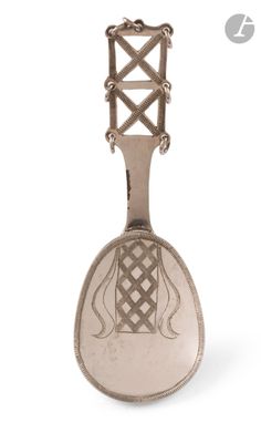une cuillère en argent ornée d'un motif sur fond blanc