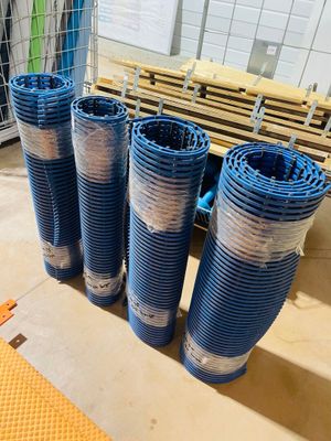 four blue plastic pipes are lined up on the floor in front of a cage