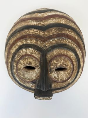 une image d'un masque en bois sur fond blanc