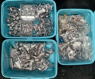 three blue plastic containers filled with assorted metal items on top of a black surface