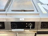 a large commercial kitchen with a stove and a grill