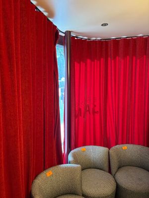 une photo d'un salon avec des rideaux rouges et un canapé