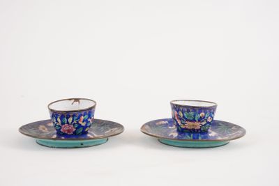 two cups and saucers sitting on top of each other on a white surface