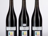trois bouteilles de vin posées l'une à côté de l'autre sur une table