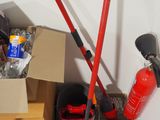 a red fire extinguisher and a black and white fire extinguisher next to a cardboard box