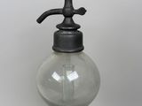 an old fashioned soap dispenser sitting on top of a table