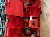 une boîte rouge posée par terre, contenant des outils