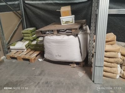 a pile of bags of cement next to a pallet of cement