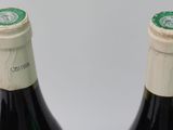 two bottles of wine sitting next to each other on a table