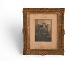 an old picture of a man in a suit and tie in a gold frame