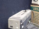 a television sitting on top of a table next to a box of boxes