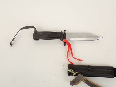 un couteau avec un manche rouge et un manche noir
