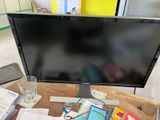 un écran d'ordinateur posé sur un bureau en bois