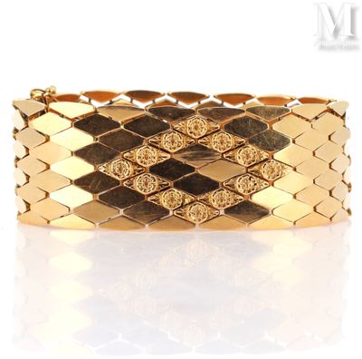 a close up of a gold bracelet on a white surface