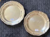 two silver plates sitting on a blue carpet next to each other