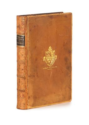 un vieux livre à la couverture dorée posé sur une surface blanche