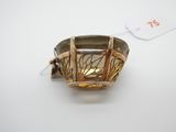 une image représentant une bague en or et en argent posée sur une surface blanche