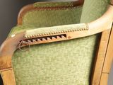 a green upholstered chair with a gun on it