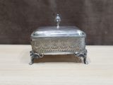 an antique silver plate with a lid on a wooden table