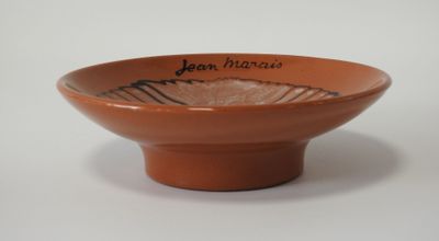 un bol marron avec une inscription, posé sur une table