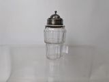 vintage salt and pepper shaker on a clear glass table
