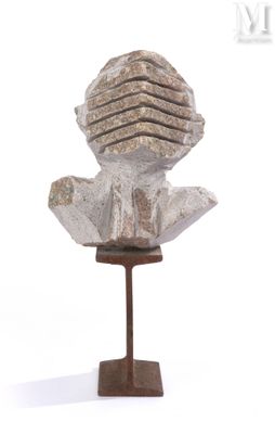 sculpture représentant une tête posée sur un socle en bois, sur fond blanc