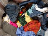 a pile of clothes that is on a bed