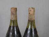 two bottles of wine sitting on top of a table next to each other