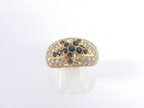 a close up of a diamond and sapphire ring on a white surface