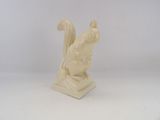 cream colored sculpture of a squirrel on a rock
