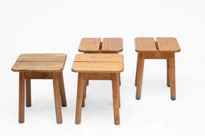 three small wooden stools sitting next to each other on a white surface