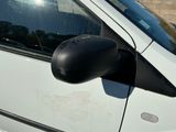 a white car with a black side mirror on the side of the road