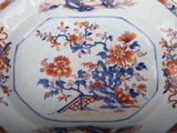 a blue and orange plate with flowers and birds on it