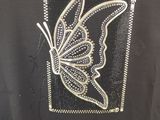 the back of a black shirt with a butterfly on it